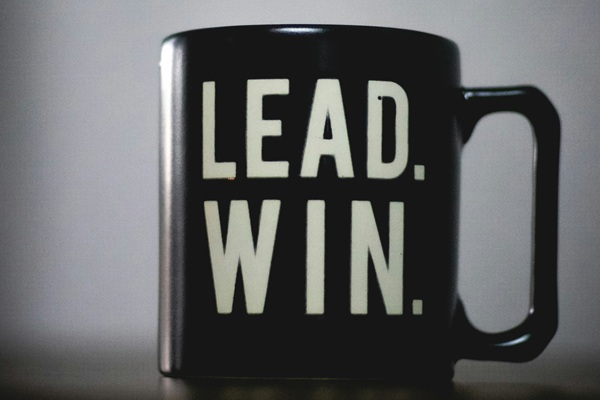 Photo of a black mug with the words "Lead. Win." in white lettering.
Photo taken by Gabriel Cox from Unsplash.